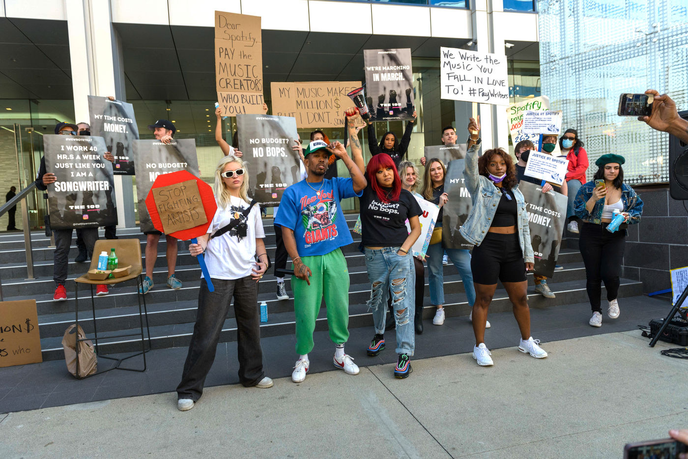 Songwriters and producers rallying with handmade protest signs