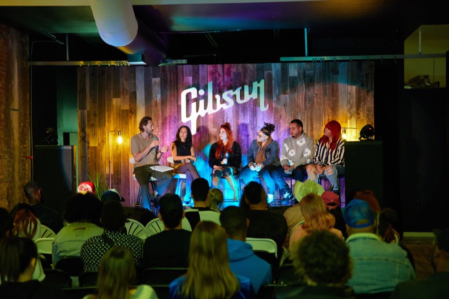 A panel of creators on stage in front of a full audience