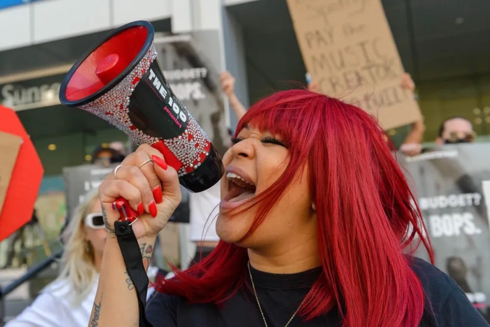 Tiffany Red shouting into a 100 Percenters megaphone at a rally