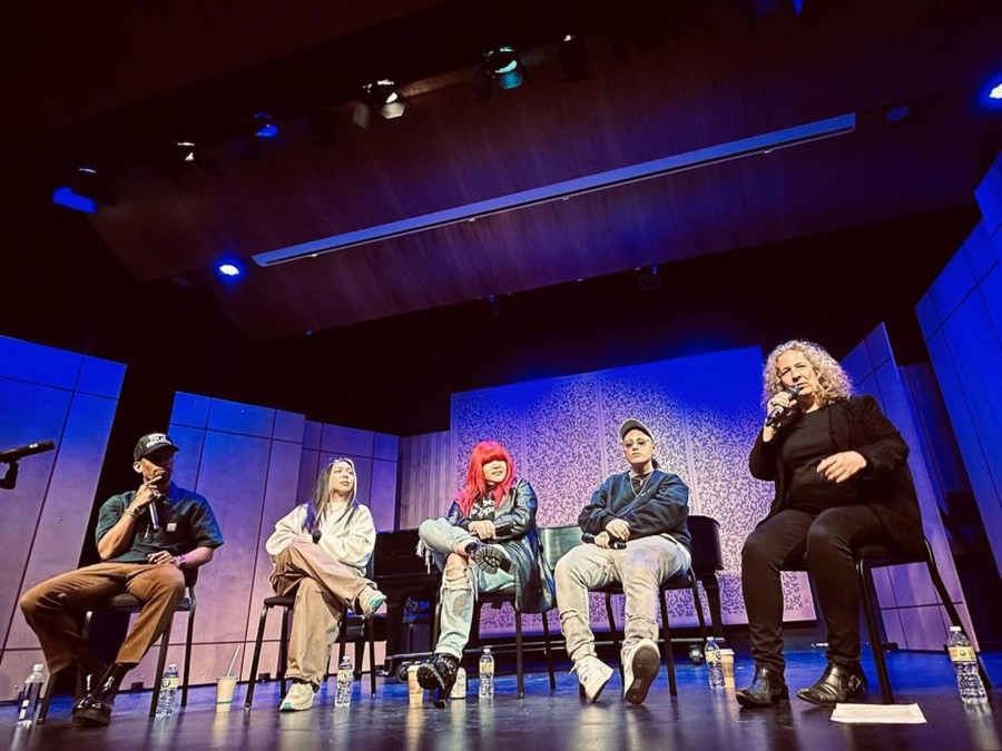 A panel of music creators speaking on stage